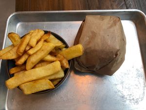 The yummy French fries (you can squirt a condiment on top of them, my choice was, of course, ketchup) and the Hatake burger in its wrapping. at Mōpa in Paris