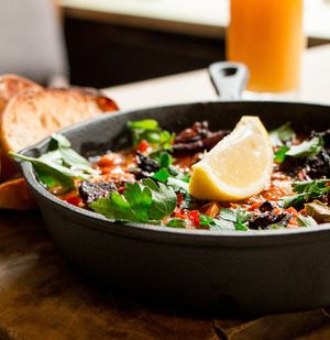 Vegan spicy baked breakfast with butter beans, home made baked beans, peppers & onion in a rich mediterranean sauce with home made jackfruit bacon, fresh parsley & lemon & ciabatta at The Queens Head in Farnham