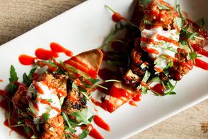 Vegan Tostadas. Harissa spiced charred cauliflower with rocket and home made salsa on our own fried tortilla chip topped with coconut creme fraiche, coriander and sriracha sauce at The Queens Head in Farnham