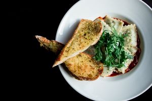 Pea & Shallot Vegan Ravioli in pomodoro sauce with crispy capers, coconut creme fraiche, rocket & garlic bread at The Queens Head in Farnham