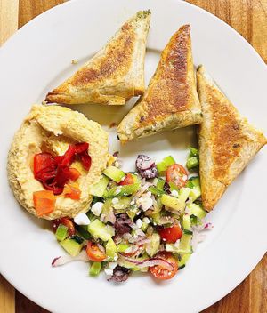 The revised Spanakopita plate w/ pastry filled kale & cheese blend (V), house hummus, roasted red peppers greek salad.  at Follow Your Heart Market & Cafe in Canoga Park