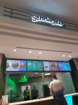 Underneath the schnitzel sign at Vedang - green burger | Mall of Berlin in Berlin