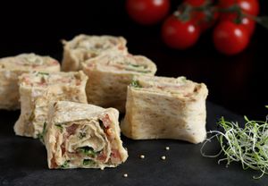 Rollini with humus. Slices of rolls in lavash with humus and fresh tomatoes. Seasoned with fresh herbs and microgreen. at Vegano Hooligano - Bohdana in Kyiv