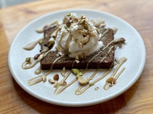 Chai buckwheat banana bread, topped with vegan ice cream, tahini caramel sauce, and crushed mixed nuts. (Requested without cinnamon.) at Little Lotus Cafe in Hobart