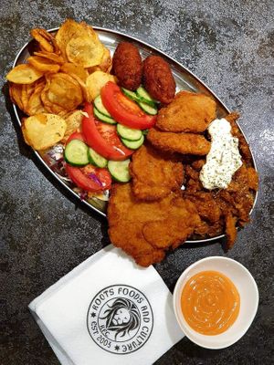 On the Plate: French Fries, Raw Salad with a Dressing, Souzoukakia, 2 varieties of Schnitzel (OysterMushrooms /Soy), Soy Gyros, Tsaziki and in the small bowl Sample Sauce  at Roots Foods and Culture in Athens