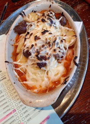 Kartoffelgratin mit Tomatensoße, veganem Käse, Oliven und Knoblauch at Kult in Wurzburg