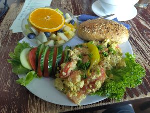 Scrambled tofu, a bowl of fruits, bread and some veggies at Kult in Wurzburg