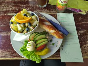 Bread, vegan butter, some veggies and a bowl with fruit, soy yogurt and oats at Kult in Wurzburg