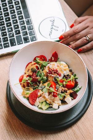 Our signature Buddha Bowl. Fresh, mixed salad, tomato, zucchini, smoked cubed tofu, onsen egg, roasted seeds, sprouts, seasonal fruits, vinaigrette at Reggeli in Pecs