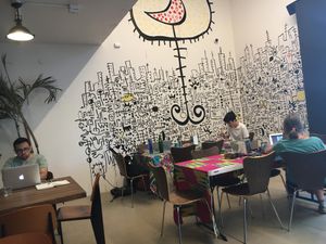 People hang out, work with their computers, look at the art in Terenga at Teranga in New York City