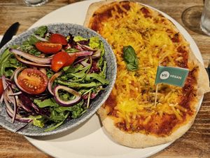 Half of a vegan Margherita with the accompanying salad at Bella Italia in Edinburgh