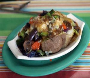 Baked potato stuffed with seasonal organic vegetables and covered in sauce. at The Spot Natural Foods in Hermosa Beach