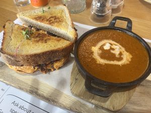 Truffle cheddar cheese with caramelized onions on sourdough served with tomato & basil soup with coconut cream and crispy onions  at Kaylee's in Johannesburg