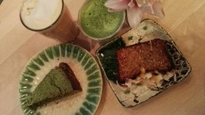 Matcha latte, chai latte with almond milk, matcha cake and mango coconut cake at Tushita in Munich