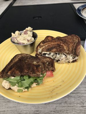 Half a chickpea salad sandwich on left, half a Reuben on right. Potato salad side at rear. at Leaf & Lentil in Sarasota