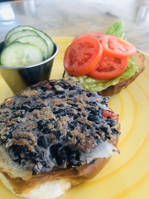 House-made black Bean Burger w/charred scallion sauce and pretzel bun   at Leaf & Lentil in Sarasota