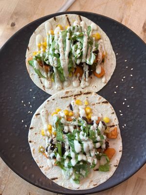 Sweet Bean Tacos
2 soft tortillas filled with organic black bean dip, guacamole, corn, sweet potato, pickled jalapeños, and topped with cashew sour cream and arugula  at Nourishmoi in Mississauga