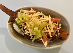 Loaded marinated carrot dog, with house made chili, violife “cheese” and all the fixins  at Veggie Thumper - Food Truck in Des Moines