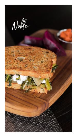 Pan artesanal vegano prensado con salteado de corazones de alcachofa y  kale. Queso de cabra opcional at Ila Barú in Chihuahua