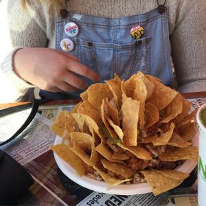 a plate of brown rice, pinto beans, guacamole, and salad with chips at The Stand Natural Foods in Laguna Beach