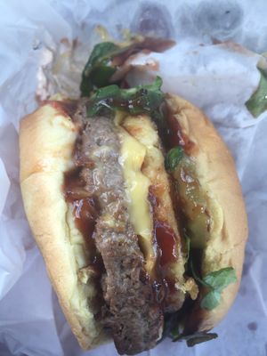 Green egg and BBQ burger with vegan cheese, vegan egg patty, and Impossible Burger patty at Vegan On The Go in Oakland Park