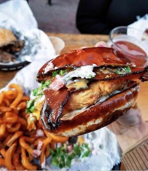 Dude Ranch Fried seitan chikun patty topped with ranch, bacun, lettuce, and tomato served on a pretzel bun. at Seitan's Realm in Columbus