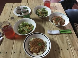 Cassava gnocchi with bolognese sauce textured and sliced ​​vegetable ham, raw salad of white lettuce, tomato, carrot, cucumber and beetroot, water of Jamaica flower. at Señor Conejo in Asuncion