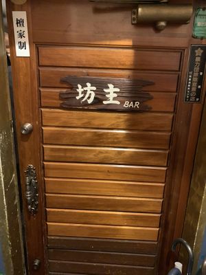 small entrance door on the 1st floor of the building  at Vowz Bar in Tokyo