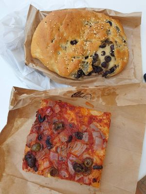 Olive focaccia; Olive and onion pizza type focaccia slice at Artemis Bakery & Pastry in Milos