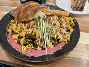 ARGI Signature beans with scrambled tofu, cheese, hash brown, bacon, and tomato on croissant.  at Argi in Kensington