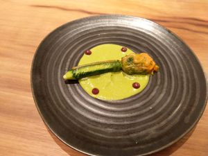 Zucchini flower filled with ratatouille and spots of kalamata olive paste at Xavier Pellicer in Barcelona