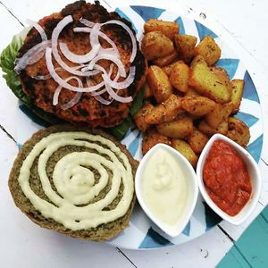 Kitchen curry burger, with home-made and baked wholegrain buns, with organic red lentil, millet and sweet potato patty, served with home-made vegan mayo, and oven-baked potatos at Pernera in Patmos