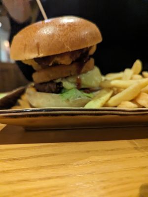 Burger includes vegan cheese, hash brown, onion rings and BBQ sauce, with chips at Harvester in Dudley
