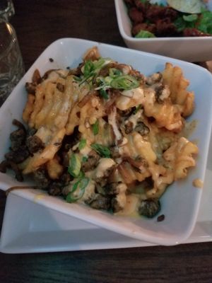 Anml fries: waffle fries, cheese sauce, mock beef, onions at Bowhead Pub in Montreal