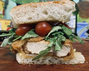 “The Iroc Z” - Battered chicken cutlet on toasted garlic bread with melted provolone, topped with an arugula and  grape tomato salad.  at Plant Based Mafia in Palm Beach Gardens
