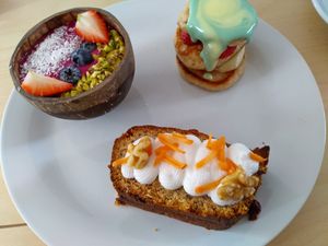 Breakfast platter: smoothie bowl, mini pancakes, carrot cake and hot drink of choice at Klein Geluk Ontbijt in Heemskerk