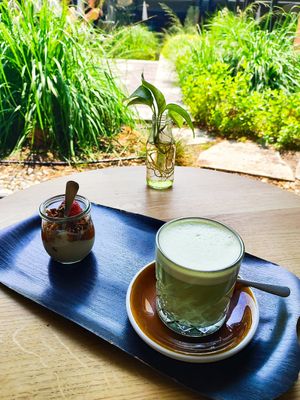 Matcha almond and small vegan granola soy yoghurt with view from inside towards the inner court terrace at Farel Bistro in Biel