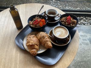 Oat milk cappuccino, vegan chocolate croissant, granola with soy yogurt   at Farel Bistro in Biel