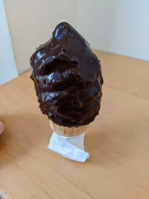 Petit size, vegan blueberry soft-serve sorbet, dipped in dark chocolate with nuts at Chocolats Favoris in Montreal