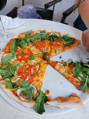 Pizza with vegan cheese, tomato, zucchini, Rucola salad and corn at Rica in Rijeka