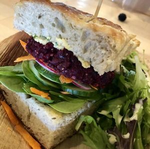 Super delicious veggie burger with a beet quinoa patty, hummus, and focaccia bread + garden salad! at Long Table Grocery in Quesnel