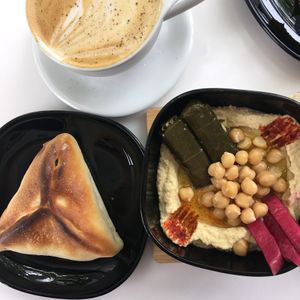 Yemeni latte with oat milk, hummus platter, and spinach pie at Qawa Coffee Co in Middletown
