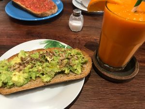 Tostadas con aguacate y semillas y zumo at La Trastienda Cafe in Alcoi