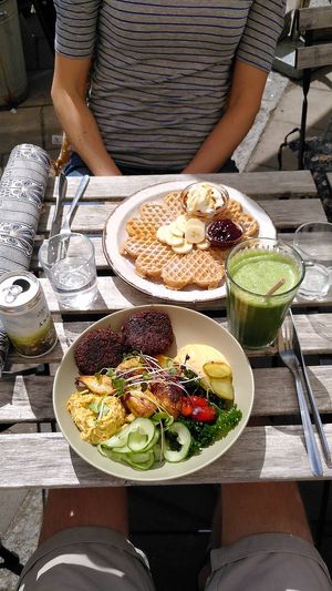 Top: vegetarian waffle with banana and berry jam (drottningsylt) - and turkish joghurt and honey. Bottom: vegan Björk bowl with among others black bean patties and chipotle mayo. at Björk in Nora