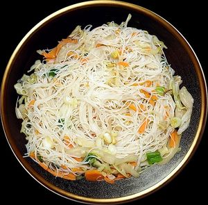 Delicate, thin rice noodles stir-fried with a vibrant medley of fresh vegetables and a subtle aromatic seasoning that highlights their light texture. at Noodle House in Istanbul