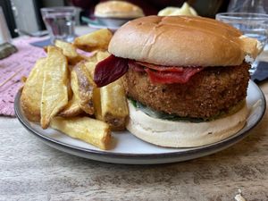 Breaded aubergine burger with vegan bacon, baby gem lettuce, and a vegan basil mayonnaise served with chips and a side of cucumber pickle.  at The Butterfly and the Pig - City Centre in Glasgow