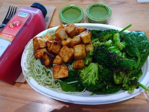 Pesto noodles, tofu, broccoli, spinach and almond salad, pesto sauce and tropical drink at Bolay in Winter Park