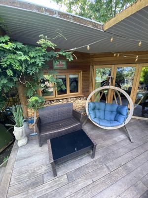 Seating area outside the cabin (the hanging seat with the blue cushions was really comfy!)  at The Base Vegan Retreat & Small Animal Sanctuary in Bristol