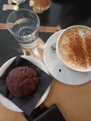 chai latte with oat milk and a vegan chocolate cookie at Drukarnia in Gdansk
