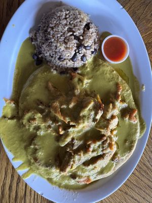 Green chili pinto bean pupusa topped with green chili sauce and soy curls  at Monse's Pupuseria in Colorado Springs